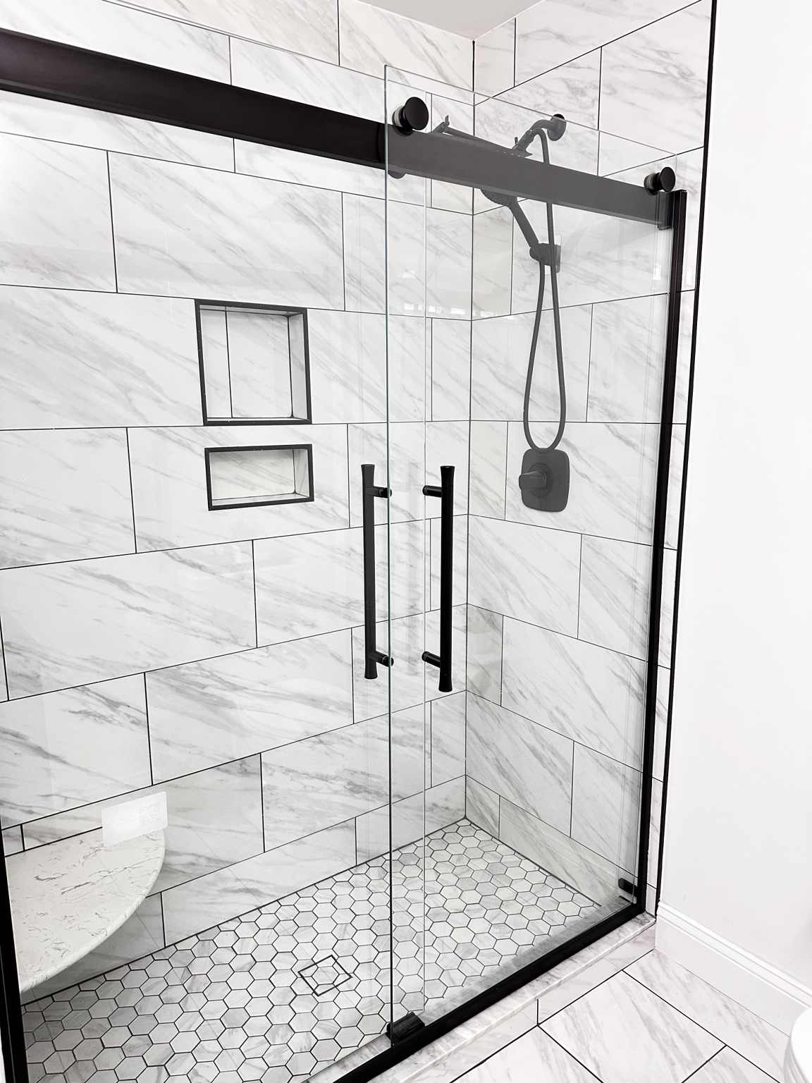 Black framed glass walk in shower by Straight Line Ceramic Tile in Wilmington NC