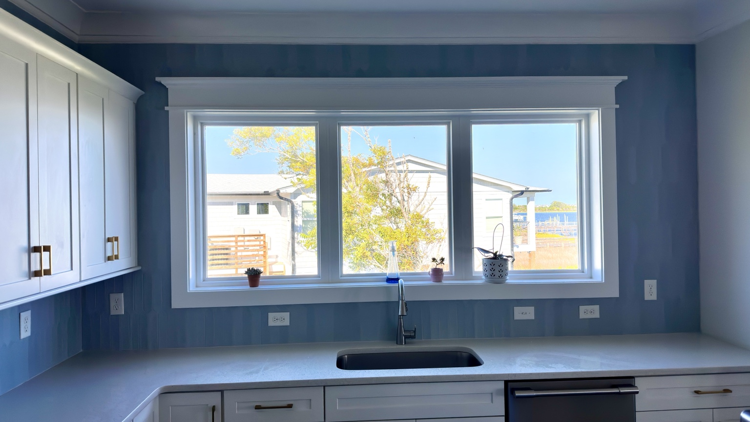 Blue tile backsplash around kitchen window by Straight Line Ceramic Tile in Wilmington NC